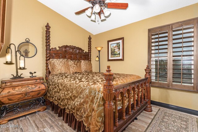 bedroom featuring hardwood / wood-style flooring, ceiling fan, and lofted ceiling