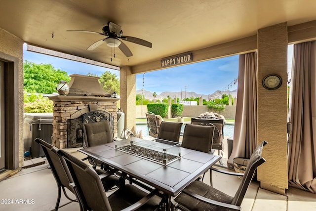 view of patio / terrace with an outdoor stone fireplace and ceiling fan