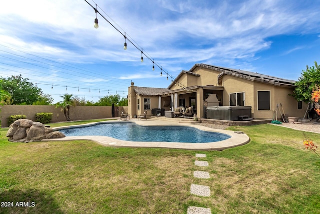 view of pool featuring a lawn, a patio area, and a hot tub