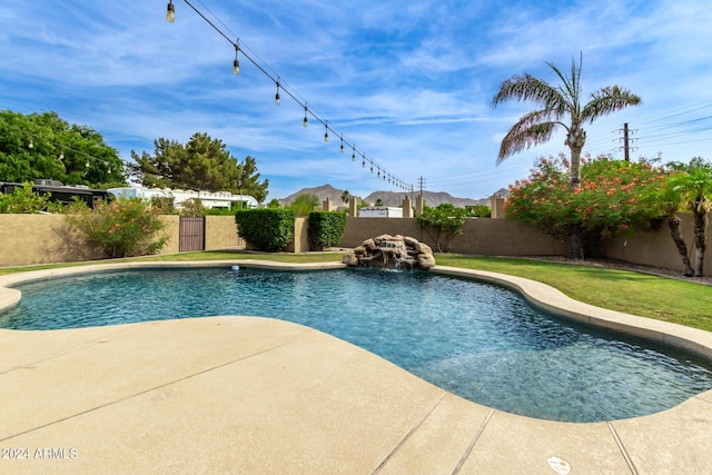 view of pool with a patio area, pool water feature, and a yard