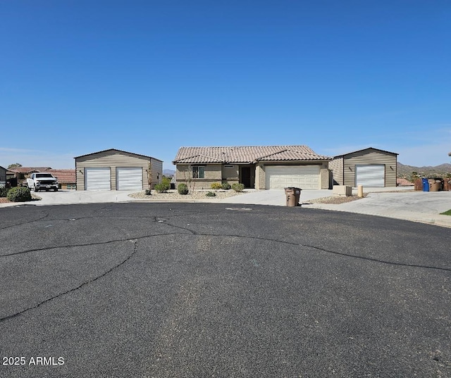 620 Vista Del Rio Ct, Wickenburg, AZ 85390 - view of front of house featuring a garage, a tile roof, and an outbuilding