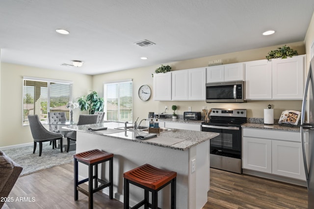 620 Vista Del Rio Ct, Wickenburg, AZ 85390 - kitchen featuring visible vents, a sink, appliances with stainless steel finishes, a breakfast bar area, and dark wood-style flooring