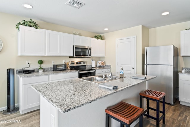 620 Vista Del Rio Ct, Wickenburg, AZ 85390 - kitchen featuring a breakfast bar, wood finished floors, visible vents, and appliances with stainless steel finishes