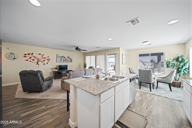 620 Vista Del Rio Ct, Wickenburg, AZ 85390 - kitchen with white cabinets, a sink, visible vents, wood finished floors, and dishwasher