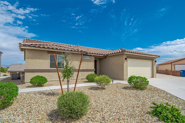 620 Vista Del Rio Ct, Wickenburg, AZ 85390 - view of front facade with a tiled roof, central air condition unit, driveway, a garage, and stucco siding