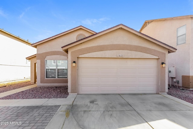 view of front of property featuring an attached garage, driveway, and stucco siding