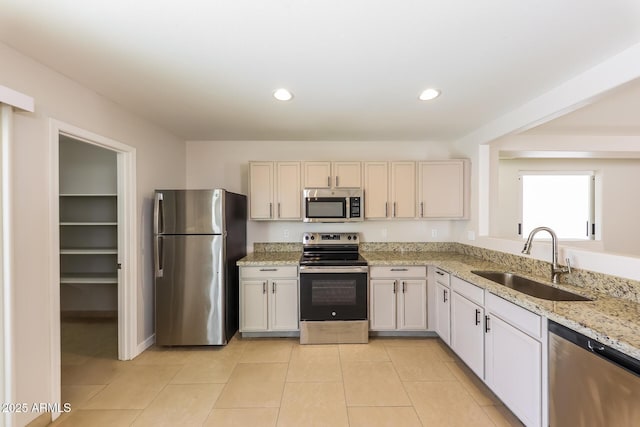 kitchen featuring light tile patterned floors, recessed lighting, appliances with stainless steel finishes, and a sink