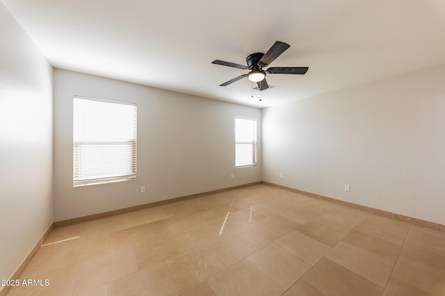 spare room featuring light tile patterned floors, baseboards, and a ceiling fan