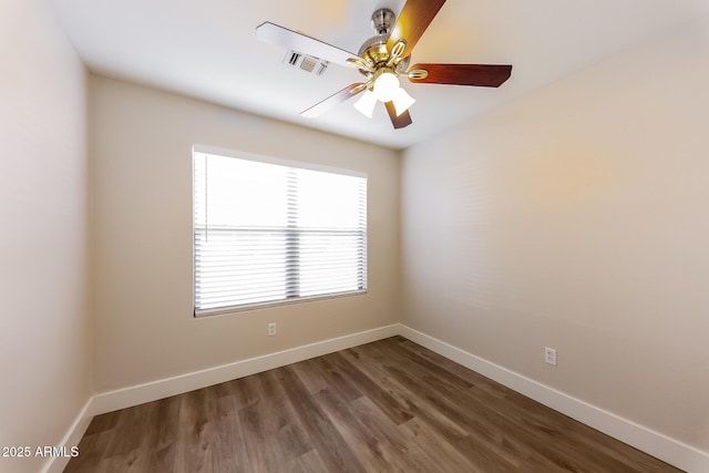 empty room with visible vents, ceiling fan, baseboards, and wood finished floors