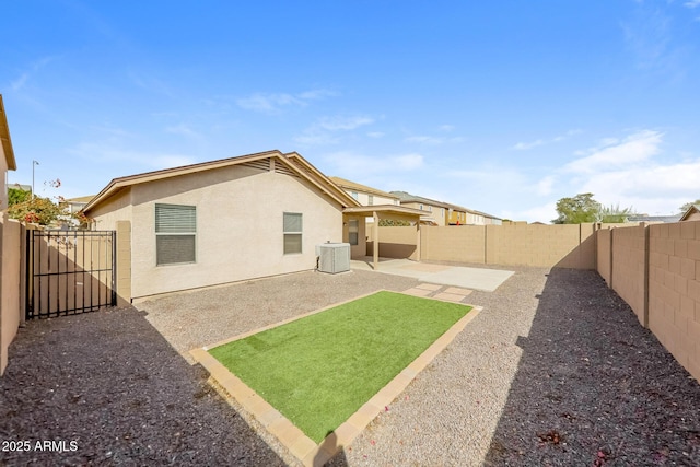 view of yard featuring central AC unit, a fenced backyard, and a patio area