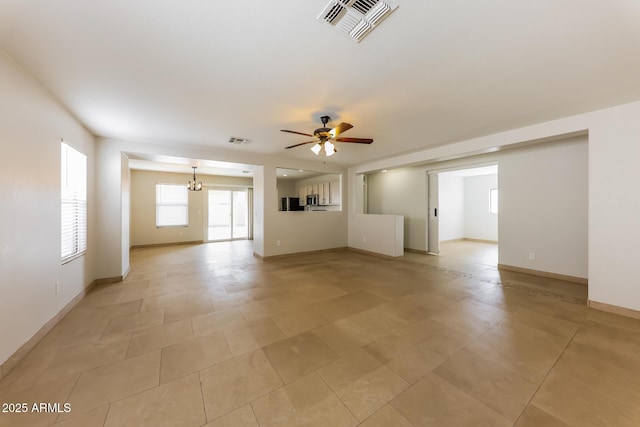 unfurnished living room with visible vents, baseboards, and ceiling fan with notable chandelier