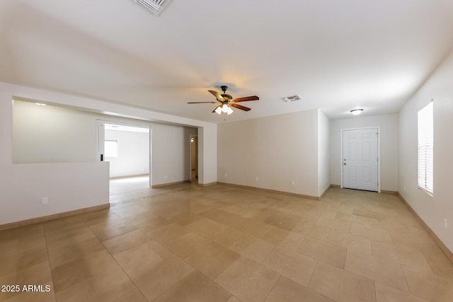 unfurnished room featuring a ceiling fan, baseboards, and visible vents