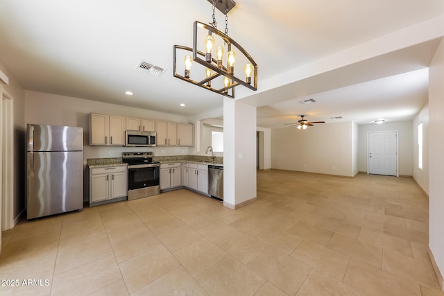 kitchen with visible vents, open floor plan, ceiling fan with notable chandelier, stainless steel appliances, and a sink