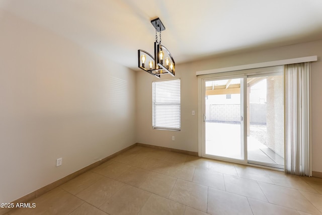 empty room featuring a chandelier, baseboards, and light tile patterned flooring