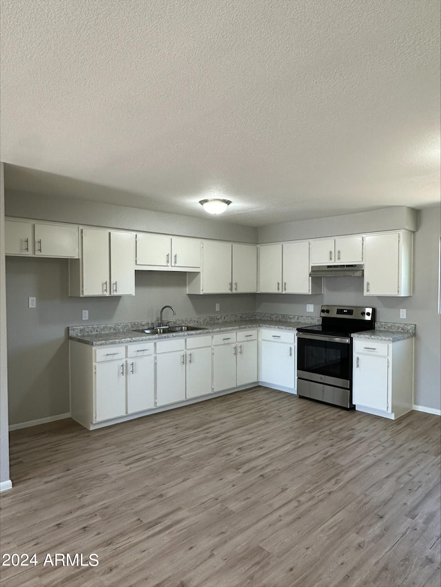 kitchen featuring white cabinetry, sink, and stainless steel range with electric cooktop