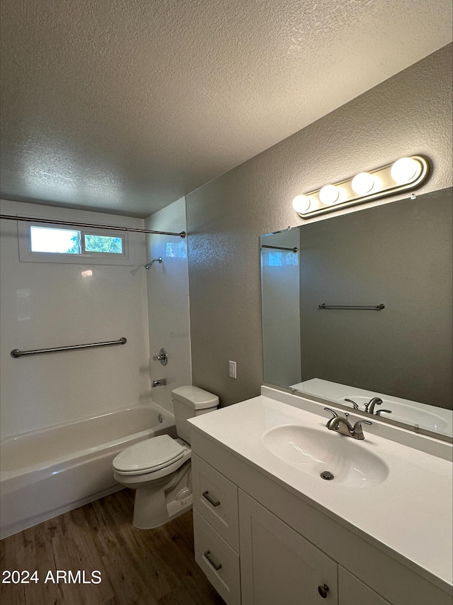 full bathroom with vanity, toilet, a textured ceiling, shower / bathing tub combination, and hardwood / wood-style floors