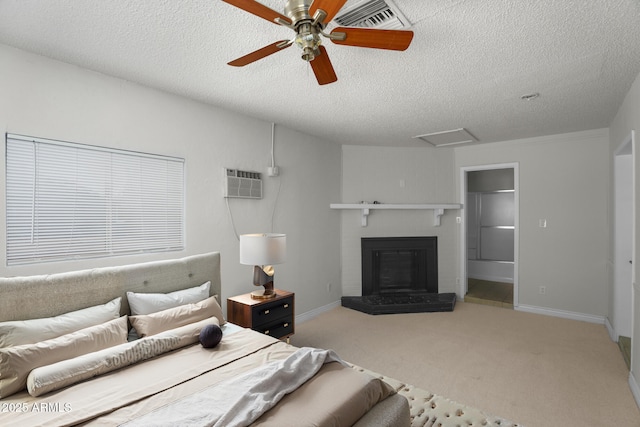 carpeted bedroom with baseboards, attic access, a textured ceiling, and a wall mounted AC
