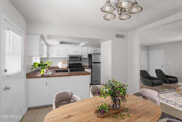 dining area featuring a chandelier, baseboards, visible vents, and light tile patterned floors