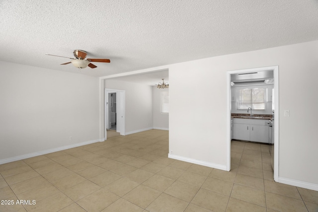 unfurnished room with light tile patterned floors, baseboards, ceiling fan with notable chandelier, and a textured ceiling
