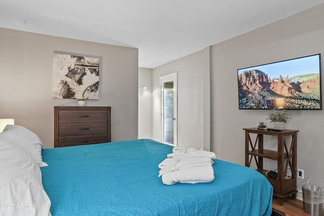 bedroom with ensuite bathroom and wood-type flooring