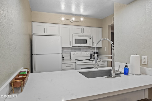 kitchen featuring white cabinetry, sink, white appliances, and decorative backsplash