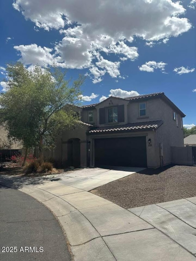 7116 S 19th Ln, Phoenix, AZ 85041 - mediterranean / spanish-style home featuring a garage, stucco siding, a tile roof, and concrete driveway