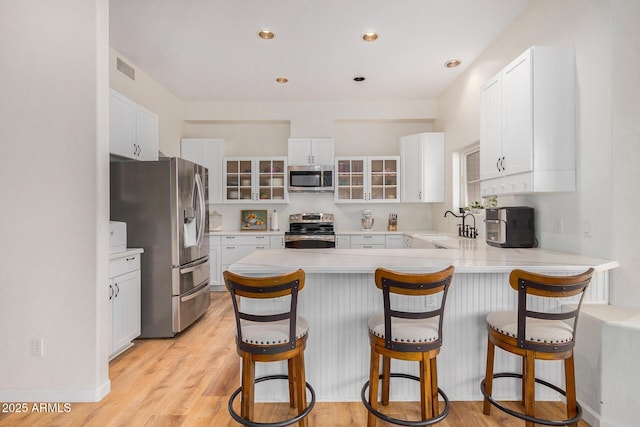 kitchen with glass insert cabinets, stainless steel appliances, and white cabinetry