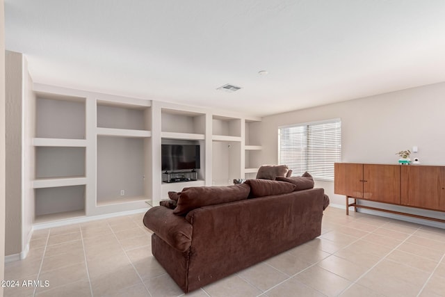 living room featuring built in shelves and light tile patterned flooring