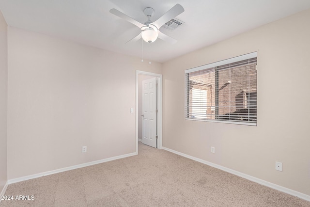 carpeted spare room featuring ceiling fan