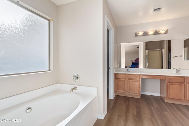 bathroom featuring hardwood / wood-style flooring, vanity, and separate shower and tub