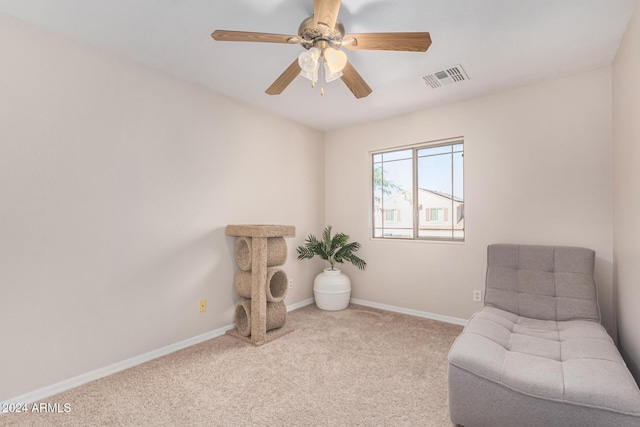 living area featuring light colored carpet and ceiling fan