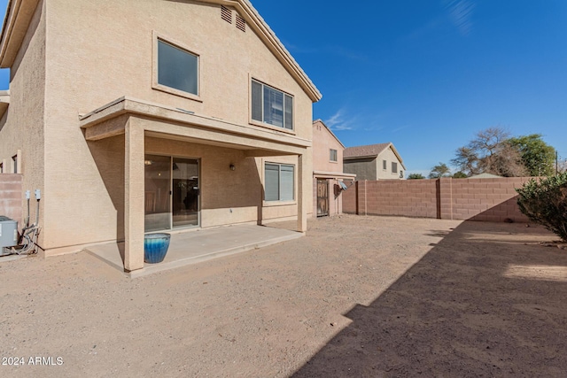 back of property with central air condition unit and a patio