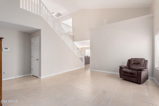 unfurnished room with light tile patterned floors, high vaulted ceiling, and plenty of natural light