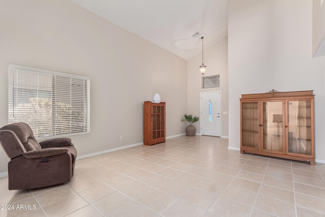 sitting room featuring high vaulted ceiling and light tile patterned flooring