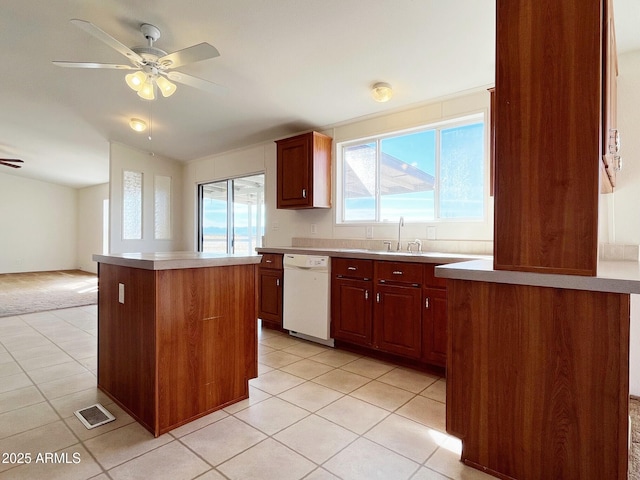 kitchen with ceiling fan, light tile patterned flooring, a kitchen island, visible vents, and dishwasher