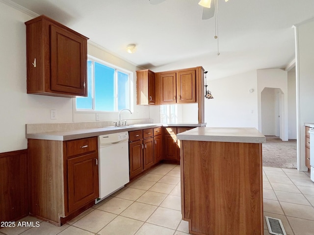 kitchen with white dishwasher, a sink, visible vents, and brown cabinets