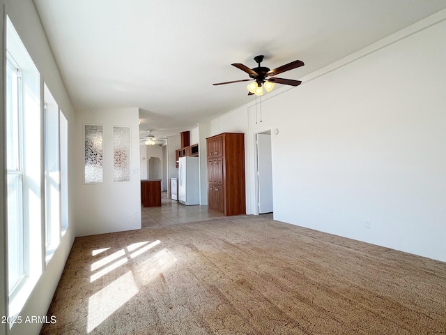 empty room featuring light carpet, ceiling fan, and lofted ceiling