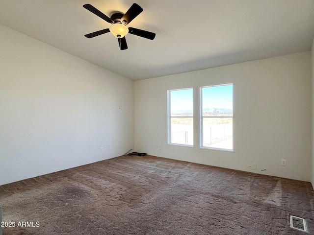 carpeted empty room with a ceiling fan, lofted ceiling, and visible vents