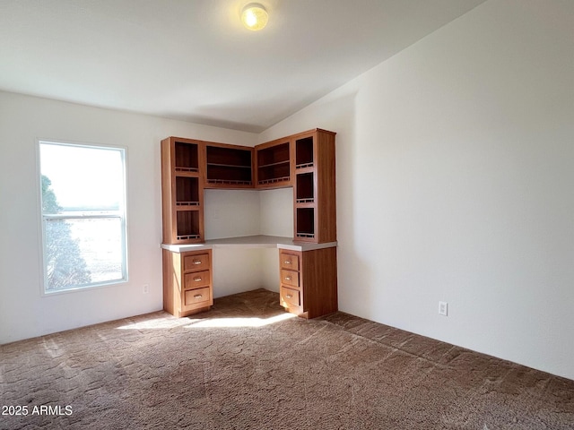 unfurnished office featuring carpet floors and vaulted ceiling