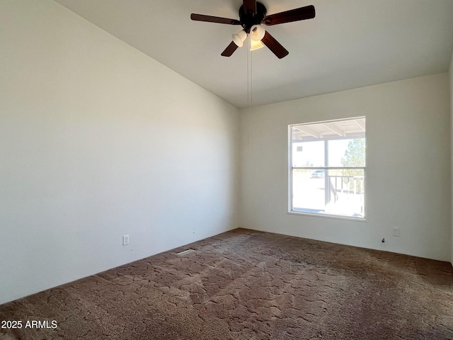 carpeted spare room with a ceiling fan and vaulted ceiling