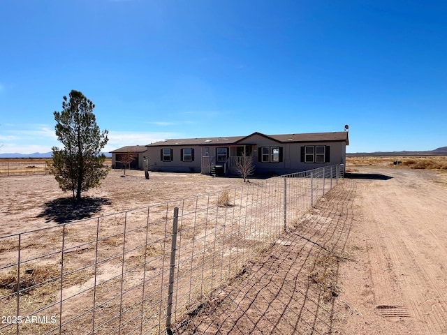 view of front of house featuring a fenced front yard and dirt driveway