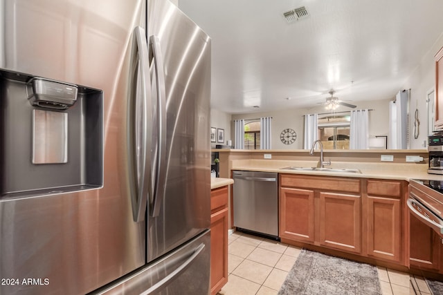 kitchen with ceiling fan, sink, light tile patterned floors, and stainless steel appliances