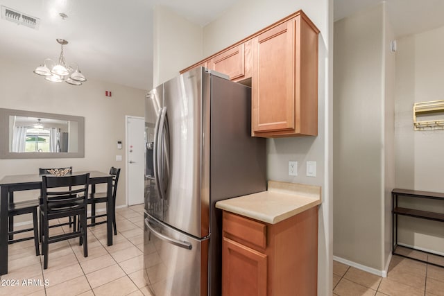 kitchen with stainless steel fridge with ice dispenser, light tile patterned floors, an inviting chandelier, and pendant lighting