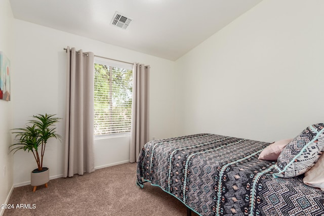 bedroom featuring light colored carpet, lofted ceiling, and multiple windows