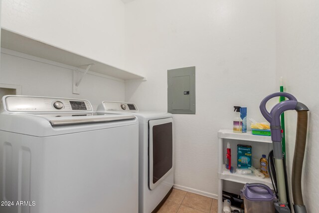 laundry room with washing machine and dryer, light tile patterned floors, and electric panel