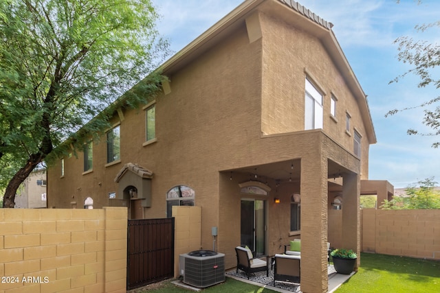 back of house with outdoor lounge area and central AC unit