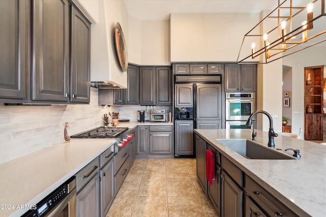 kitchen featuring an inviting chandelier, sink, hanging light fixtures, tasteful backsplash, and light tile patterned flooring