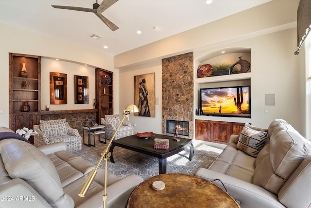 living room with built in shelves, ceiling fan, and a fireplace