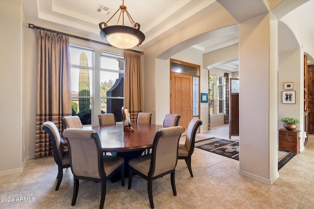 tiled dining space featuring a tray ceiling