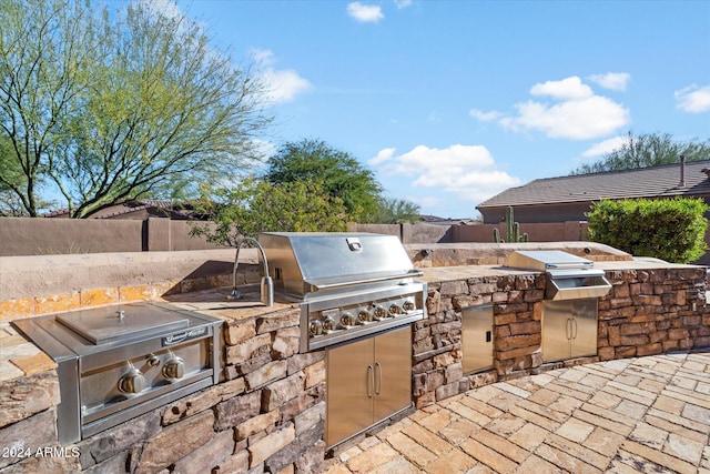 view of patio with an outdoor kitchen and a grill